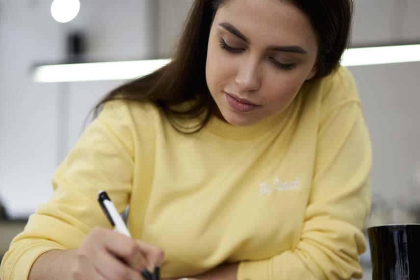 Student sitting an exam with a yellow sweater on