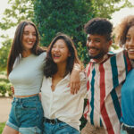 Group of 4 laughing young graduates