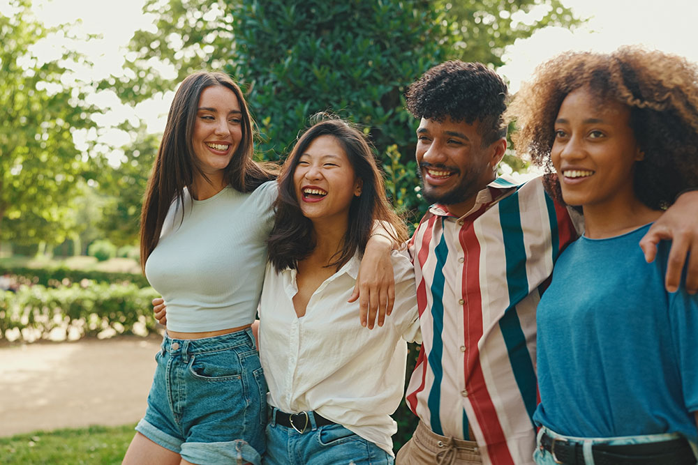 Group of 4 laughing young graduates